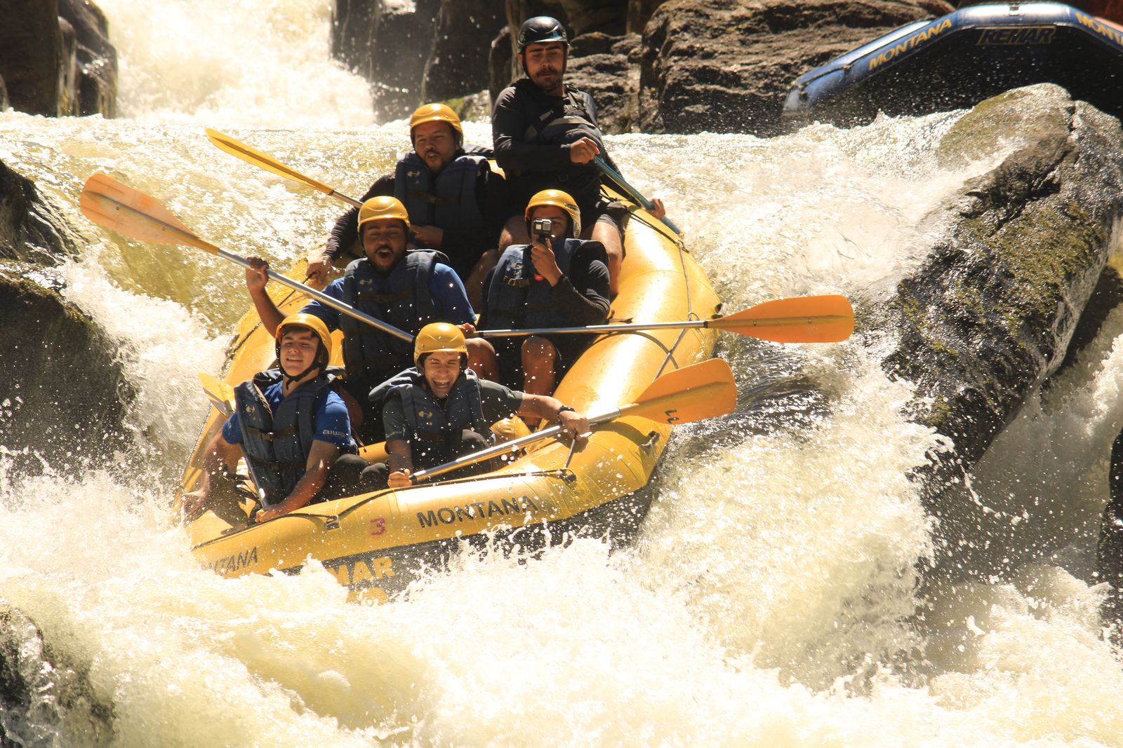 Turma comemorando no bote da Montana no meio de uma queda d'água forte do Braz Adão
